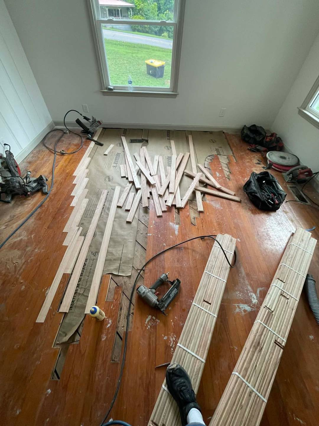 Board replacement in progress with nail gun and bundled boards
