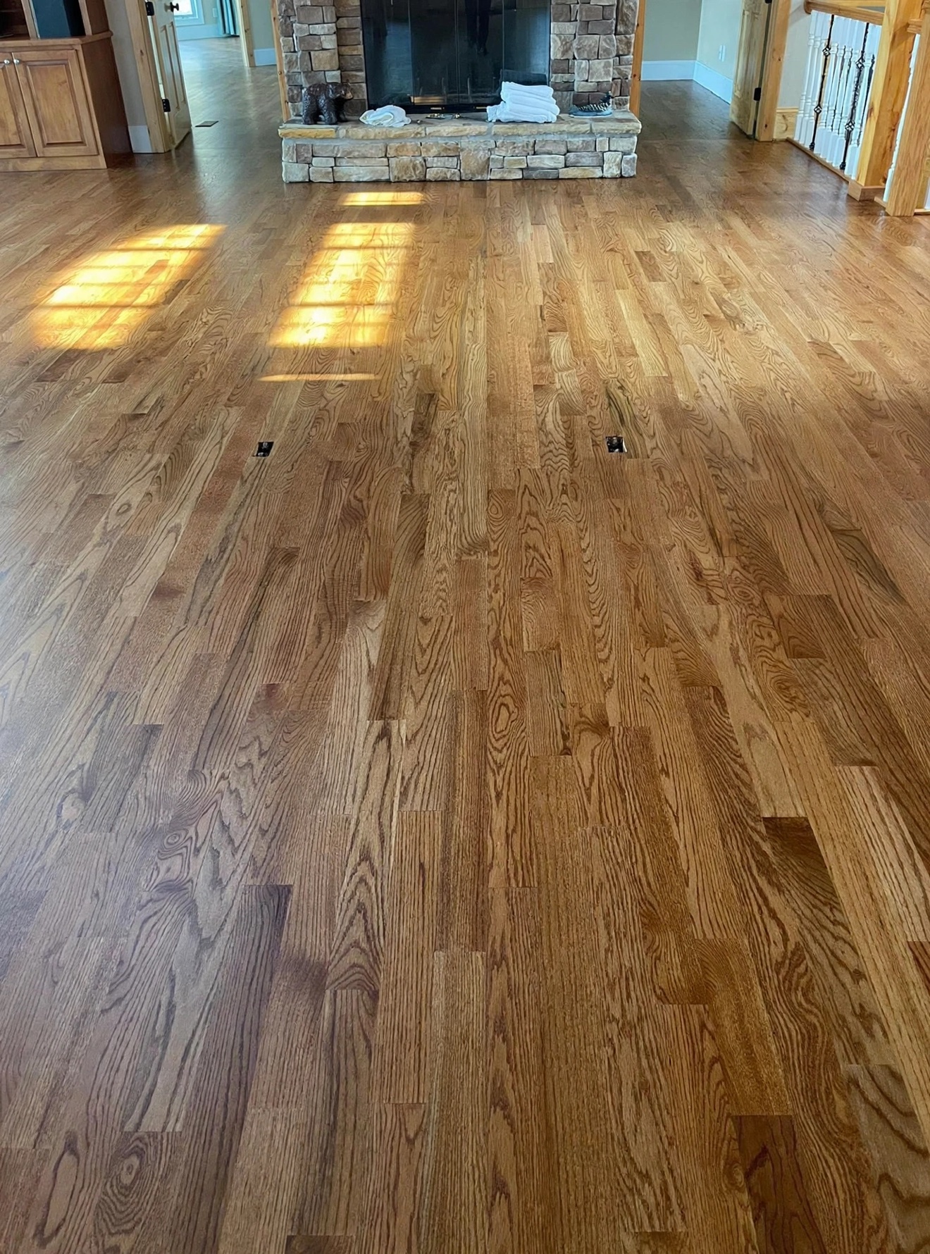 Freshly re-coated oak hardwood floor in a living room with a fireplace