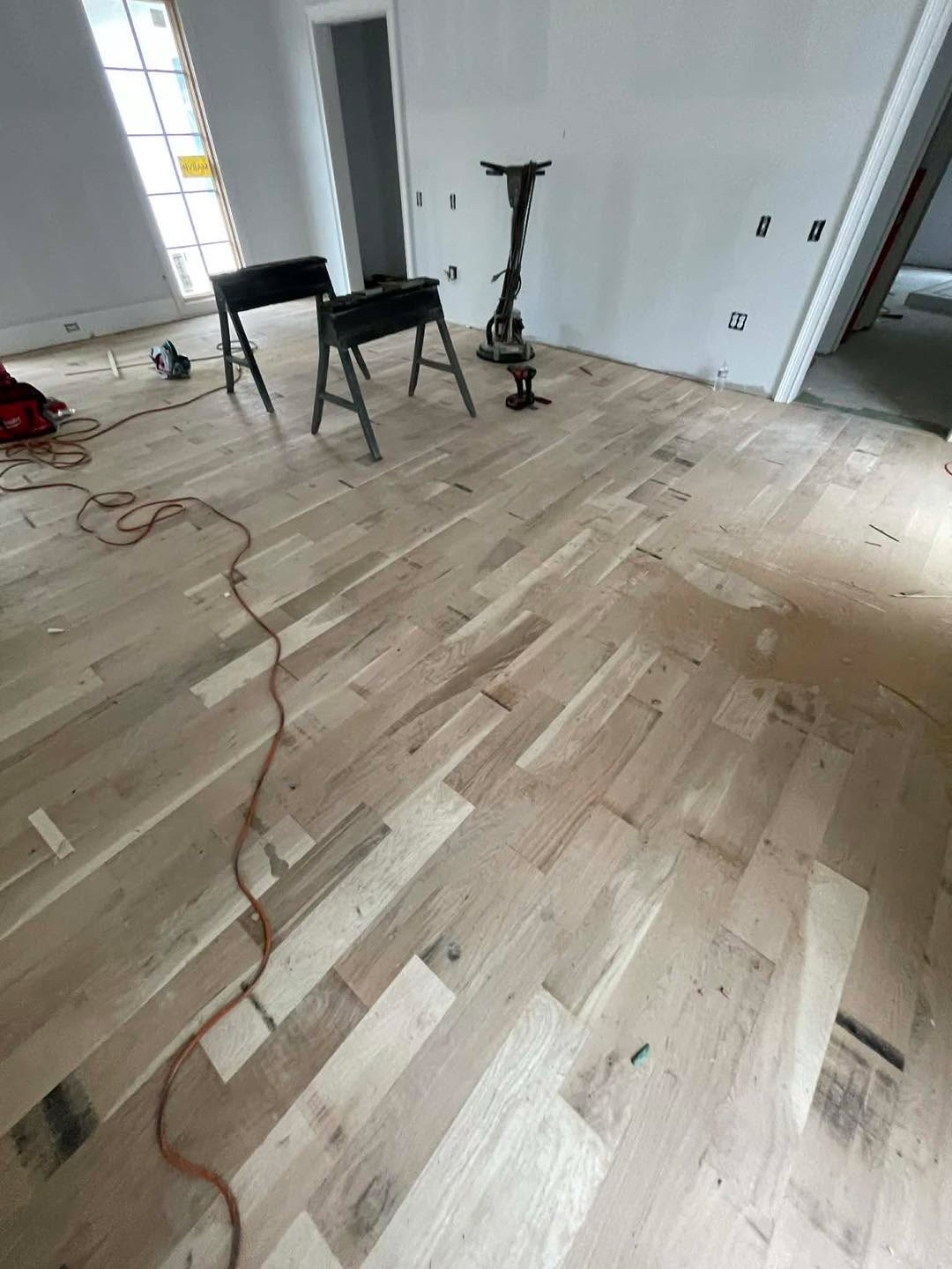 Newly installed light floor with sander and sawhorses