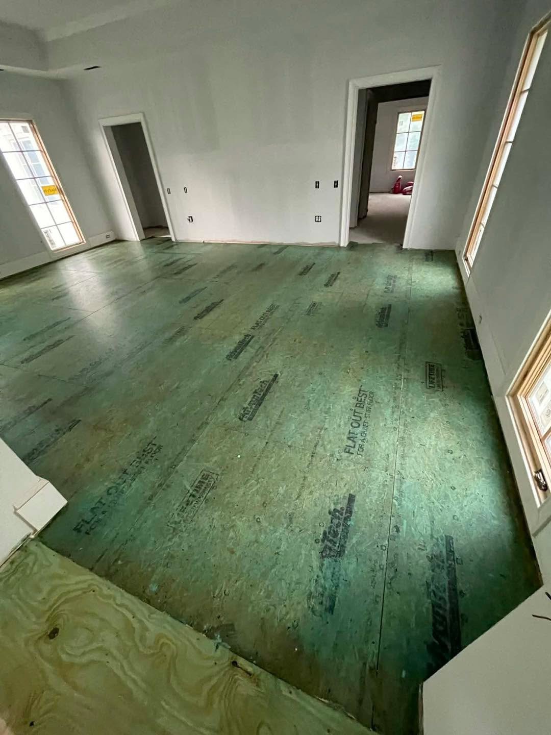 Empty room with green underlayment ready for installation