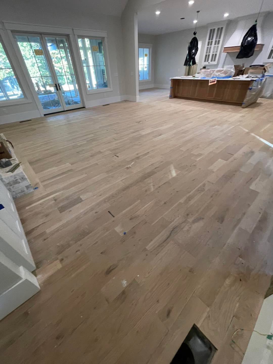 Finished light floor from another angle, kitchen island and French doors