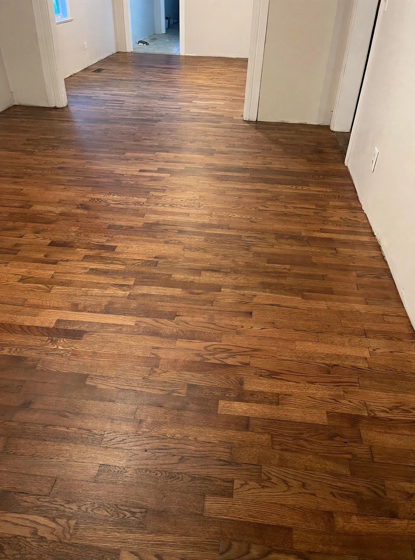 Dark-stained refinished hardwood flooring in an empty room