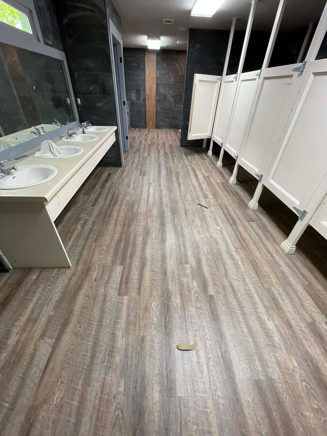 Commercial restroom with light gray wood-look plank floor